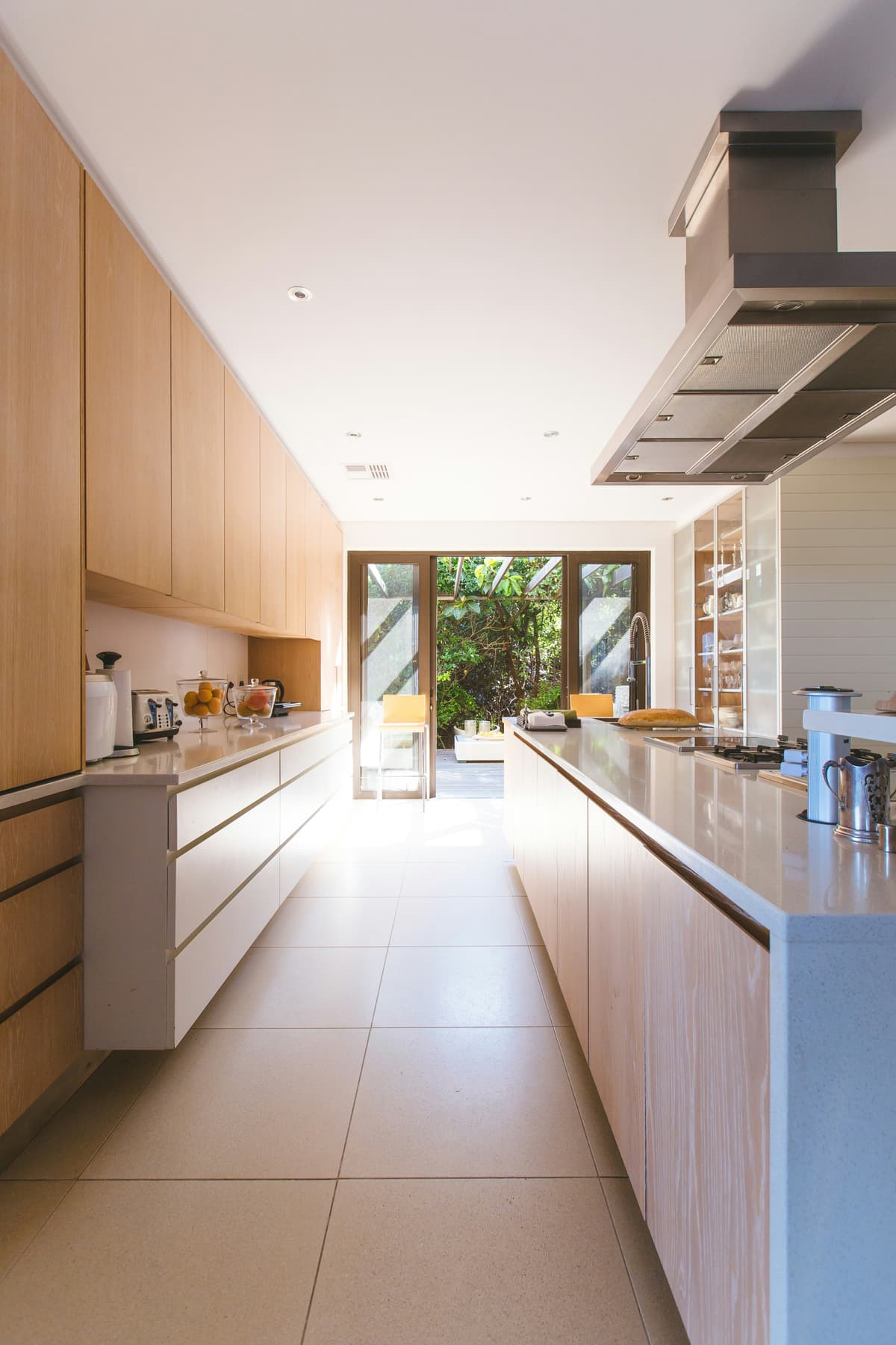 Light galley kitchen with painted walls opening onto a garden